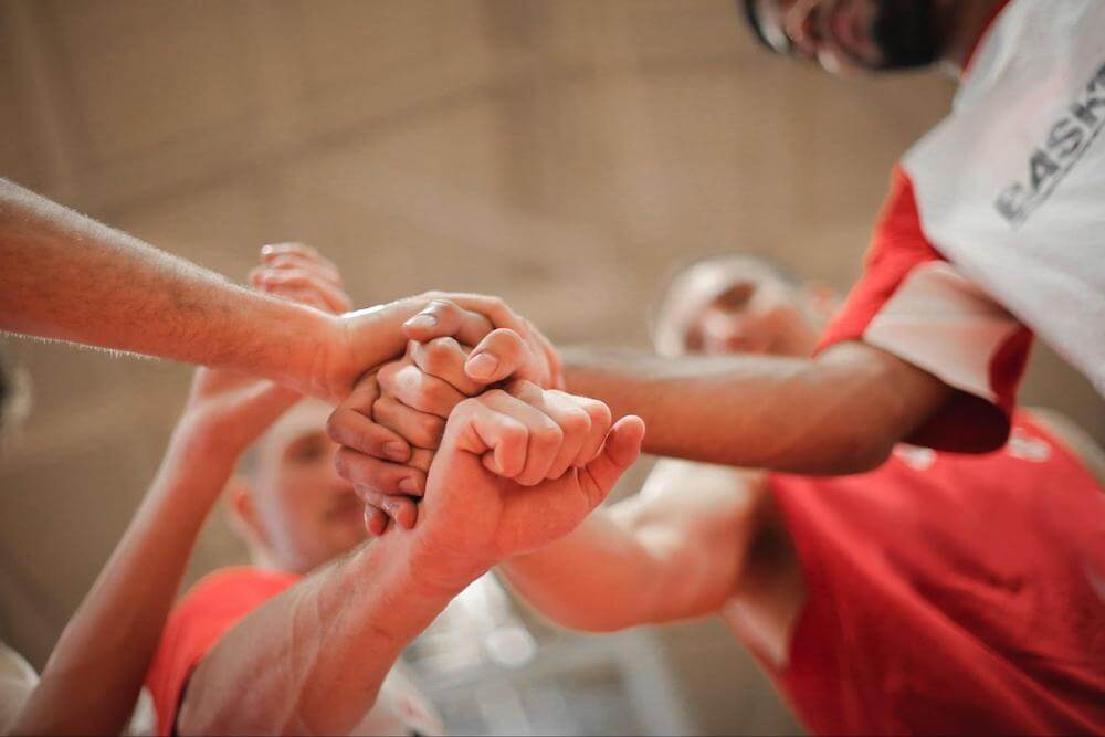 group of 4 people put their hands in before a game