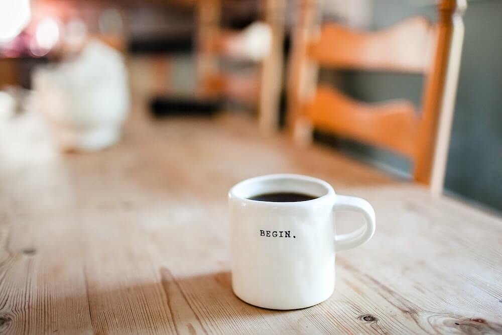 coffee mug that says begin on it.